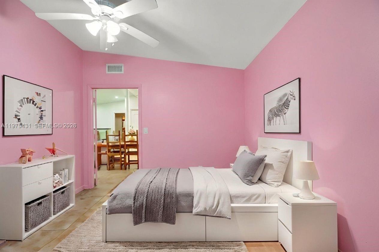A bedroom features pink walls, a white bed, and a white dresser — 11809 NE 1st Ave, Miami FL 33161, MIAMI, FL
