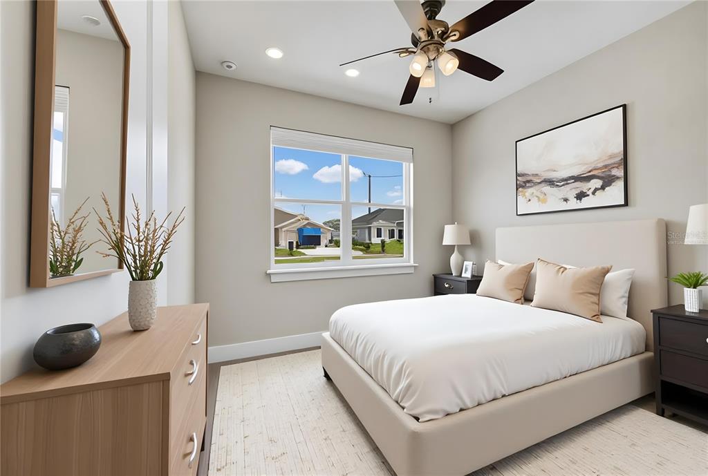 A bedroom features a bed, dresser, ceiling fan, and a window looking out at houses — 806 COLVILLE DRIVE, KISSIMMEE, FL