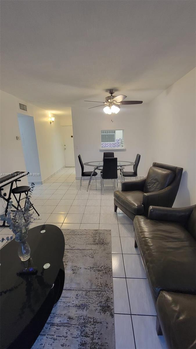 A living and dining area features white walls, tiled floors, and dark leather furniture — 6820 W Flagler St # 207, Miami FL 33144, MIAMI, FL