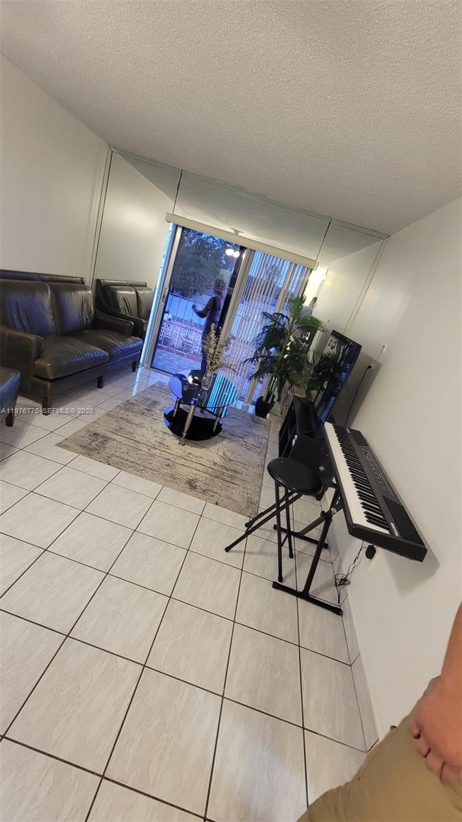 A living room features white tile floors, a dark leather sofa, and a digital keyboard — 6820 W Flagler St # 207, Miami FL 33144, MIAMI, FL