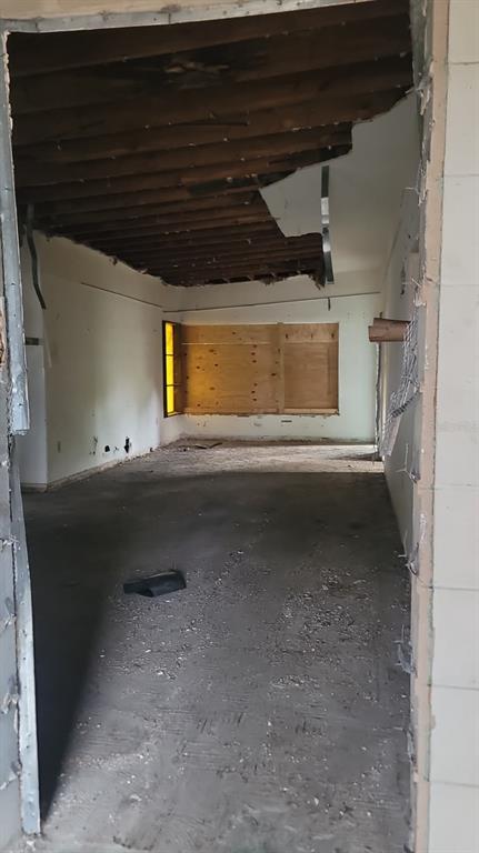 An interior view of a room under renovation with exposed ceiling joists and boarded windows — 1024 W FAIRBANKS AVENUE, ORLANDO, FL