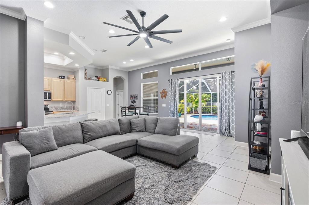 A gray sectional sofa sits on a rug in a living room with tile floors — 22608 KILLINGTON BOULEVARD, LAND O LAKES, FL