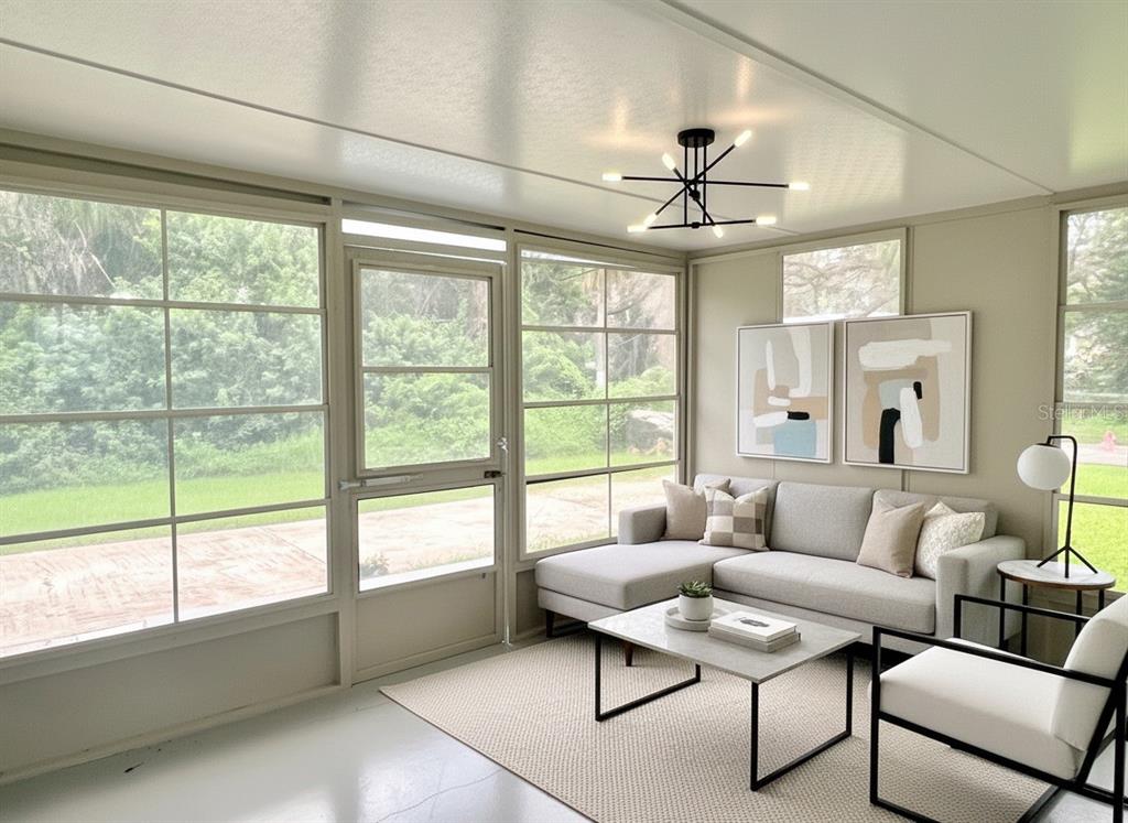 A sunroom features a light gray sectional sofa, a coffee table, and large windows — 5045 GREEN KEY ROAD, NEW PORT RICHEY, FL
