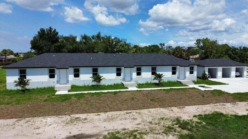 An exterior view of a white, single-story multi-unit building with a dark shingled roof — 260 W Rotonda Blvd W # 3, FL 33947, FL