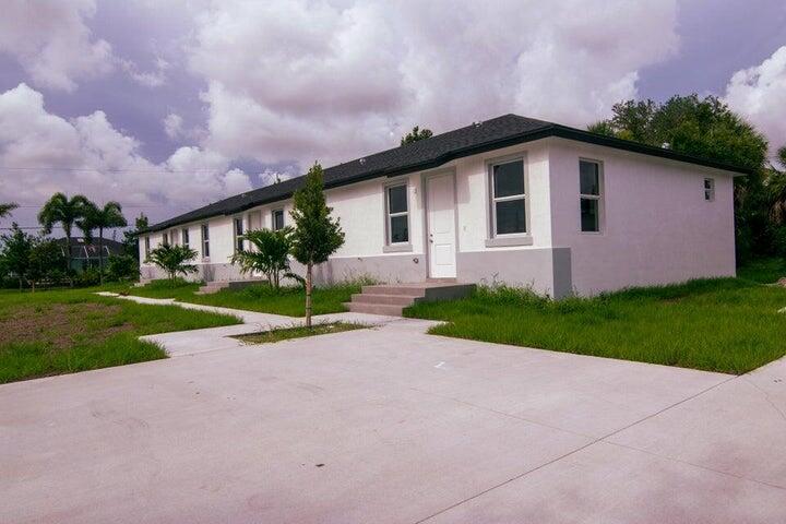 A long, single-story white building with a dark roof and a large concrete parking area — 260 W Rotonda Blvd W # 3, FL 33947, FL