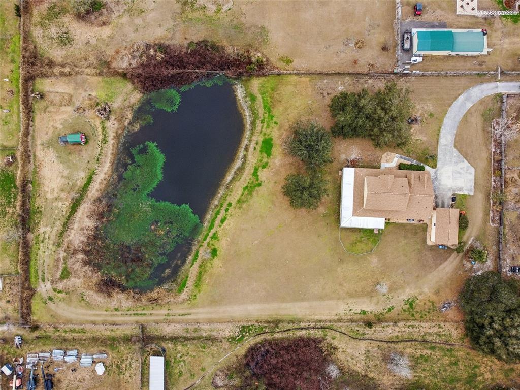 A two-story house with tan siding, stone veneer, and a covered front porch at sunset — 2921 LAMPP ROAD, PLANT CITY, FL