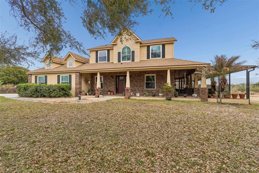 An aerial view shows a house with a driveway, a pond, and surrounding grassy land — 2921 LAMPP ROAD, PLANT CITY, FL