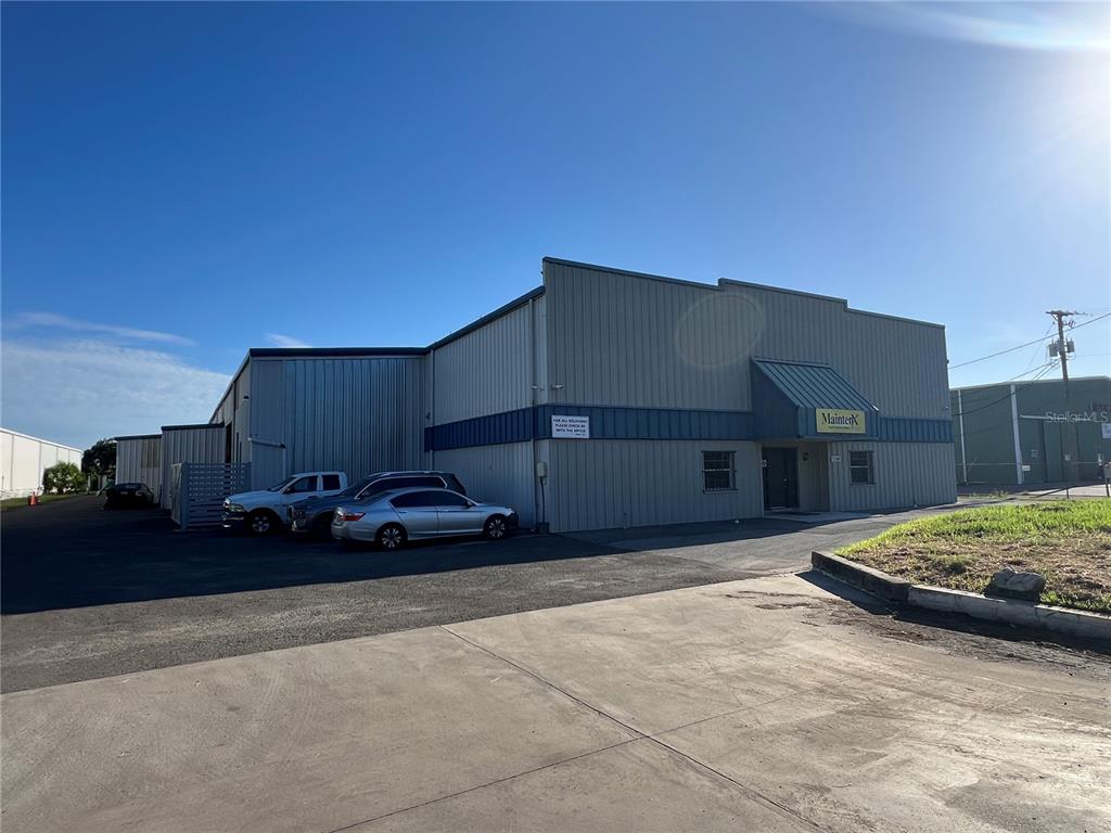 A commercial warehouse building with a metal exterior and a parking lot in front — 5208 SAINT PAUL STREET, TAMPA, FL