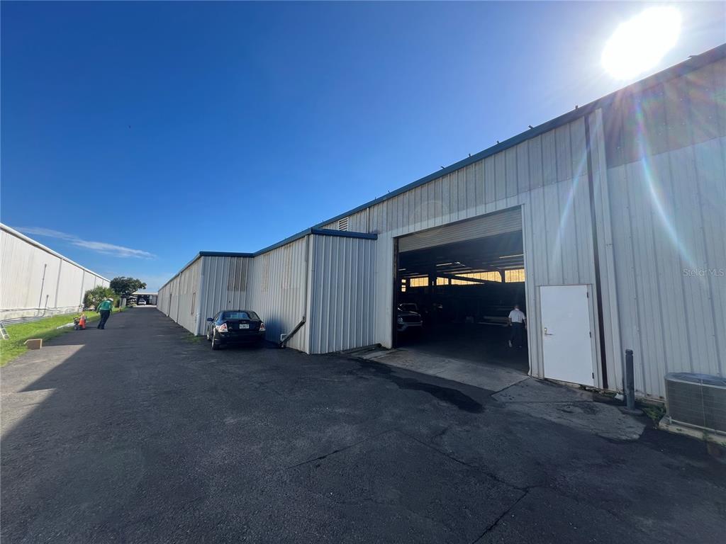 An exterior view of a metal warehouse building with a large open bay door — 5208 SAINT PAUL STREET, TAMPA, FL