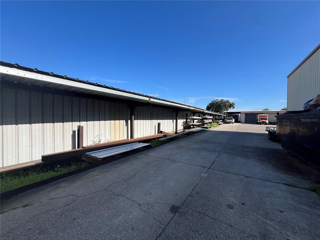 An outdoor storage area features a long metal-sided building with open bays and concrete flooring — 5208 SAINT PAUL STREET, TAMPA, FL