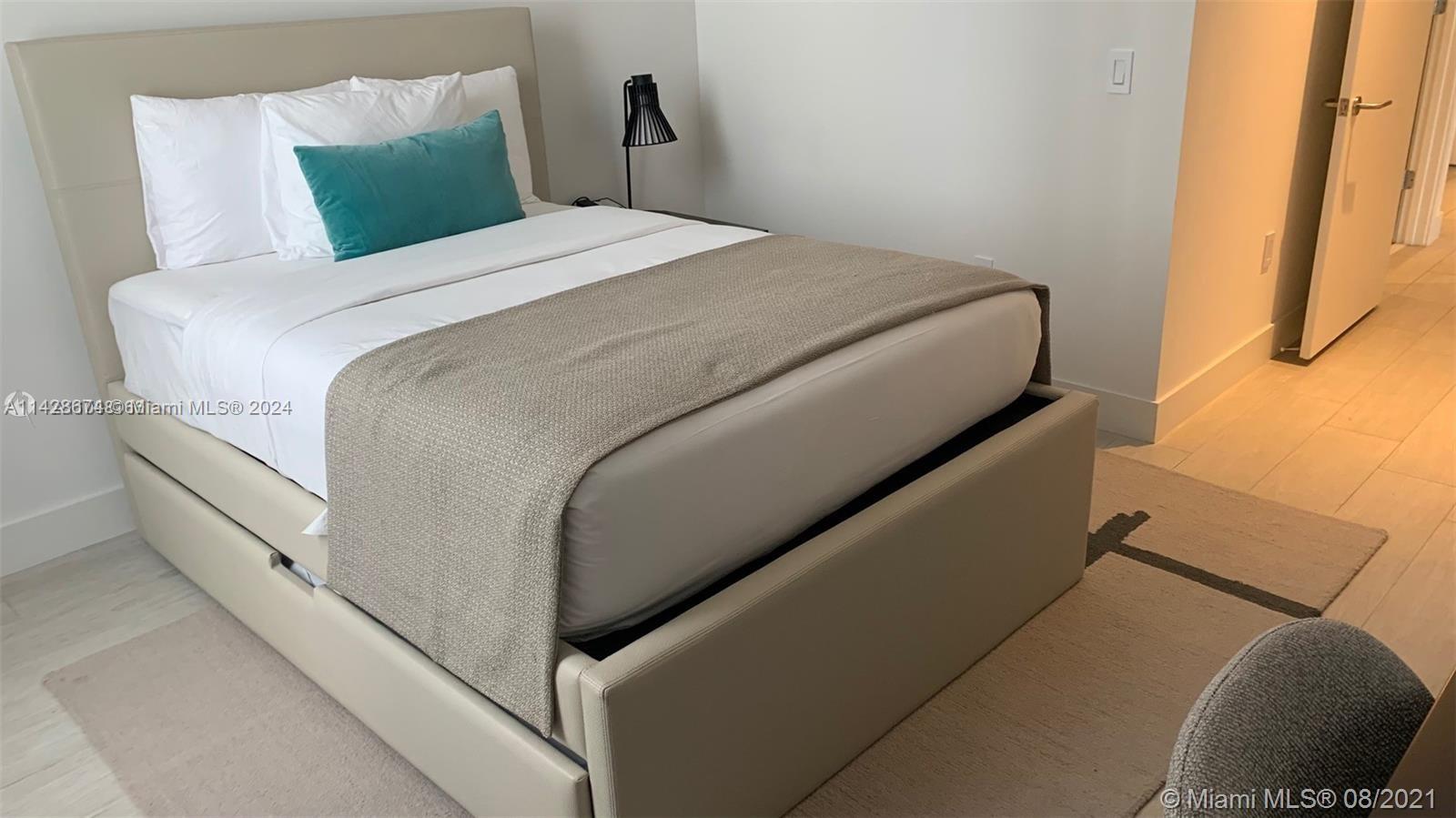 A bedroom features a beige upholstered bed with a teal accent pillow and a runner — 4010 S Ocean Dr # R301, Hollywood FL 33019, HOLLYWOOD, FL