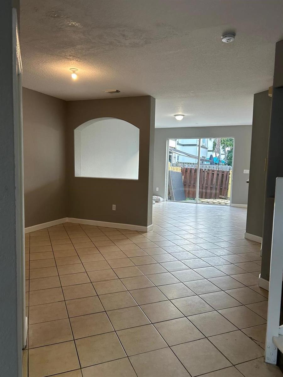 An interior view of a room with beige tile flooring, gray walls, and an arched niche — 11486 NW 77th Street, Doral FL 33178, DORAL, FL