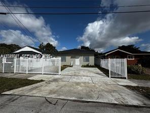 A kitchen features white cabinets, stainless steel appliances, and marble-patterned countertops and flooring — 1717 NW 70th St, Miami FL 33147, MIAMI, FL