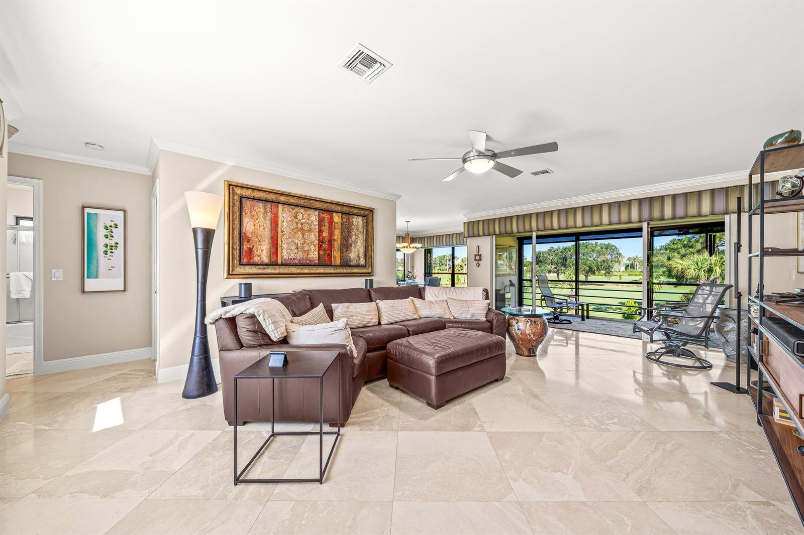 A living room features a brown sectional sofa, tile flooring, and sliding doors to a balcony — 10221 Quail Covey Road, Boynton Beach FL 33436, BOYNTON BEACH, FL