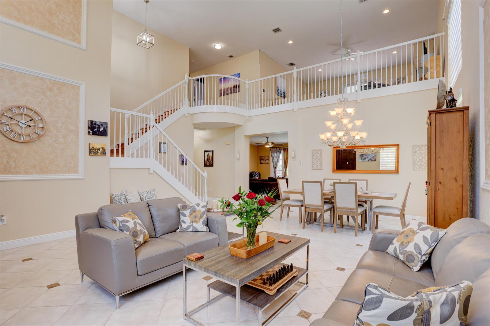 A living and dining area features a staircase, high ceilings, and light-colored tile flooring — 19644 Estuary Drive, Boca Raton FL 33498, BOCA RATON, FL