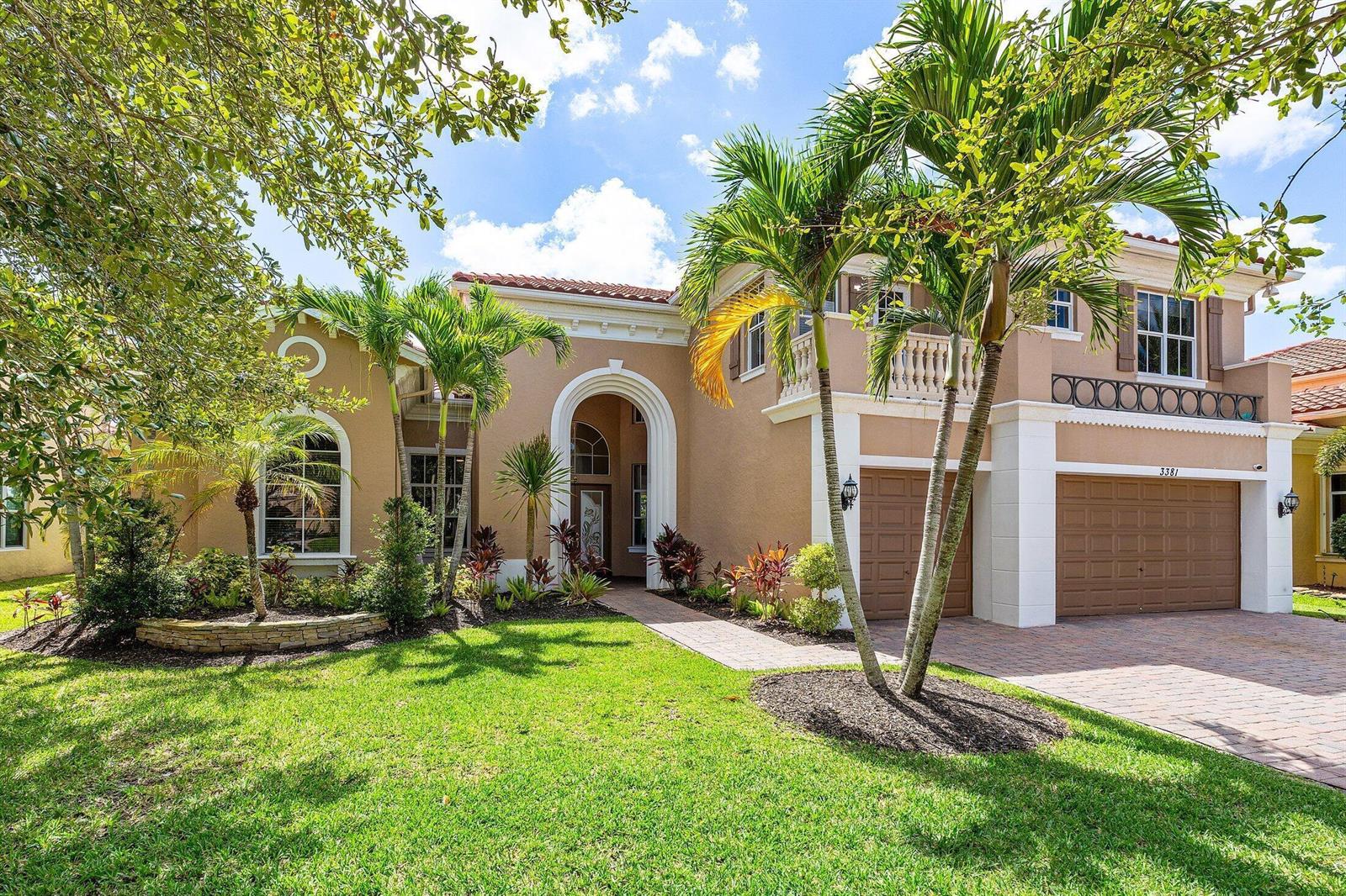 A two-story stucco house with a tiled roof, arched entryway, and a paved driveway — 3381 Lago De Talavera, Lake Worth FL 33467, LAKE WORTH, FL