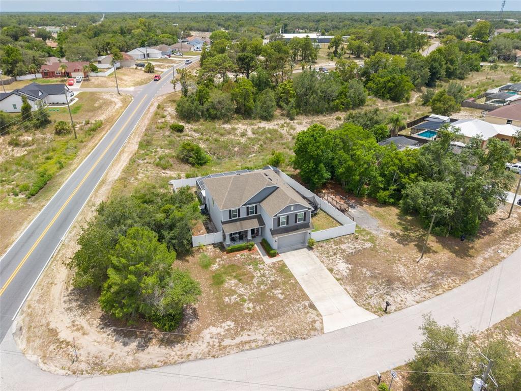 An aerial view shows a two-story house with a fenced backyard and pool — 7242 LANDMARK DRIVE, SPRING HILL, FL