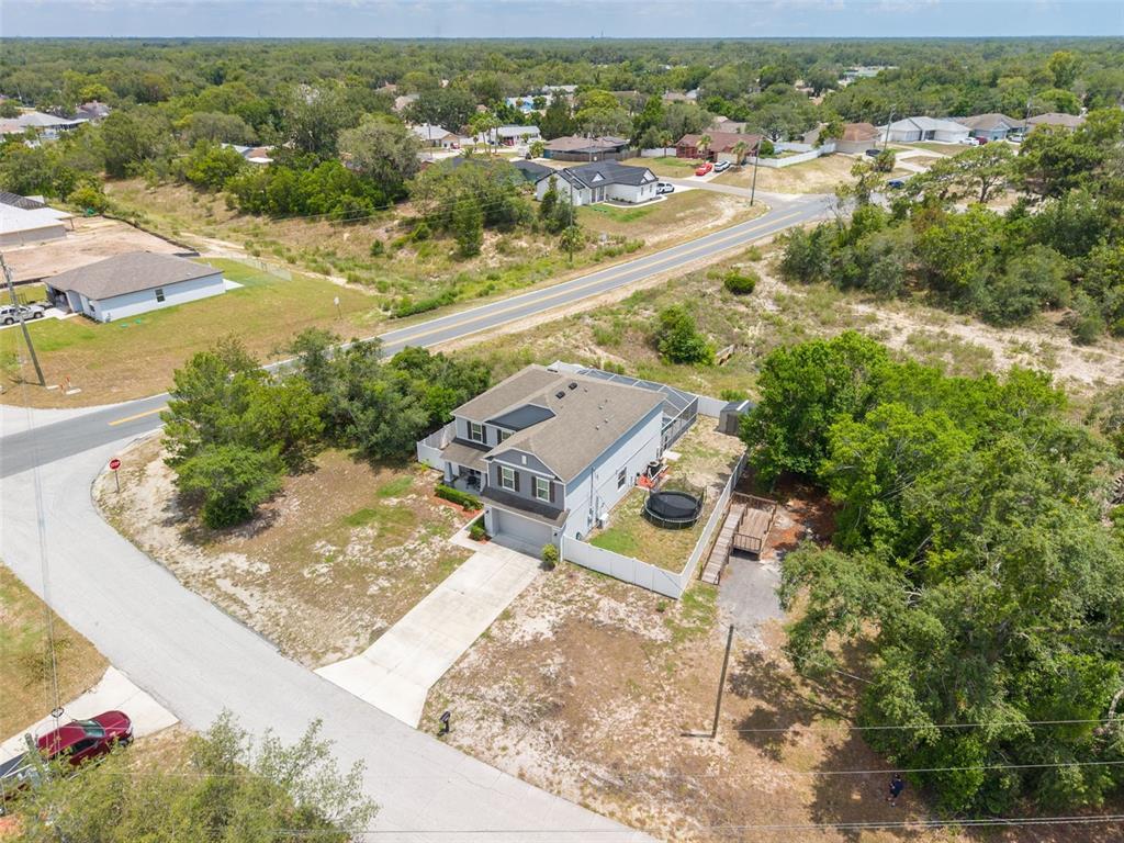 An aerial view shows a two-story house with a fenced backyard and driveway — 7242 LANDMARK DRIVE, SPRING HILL, FL