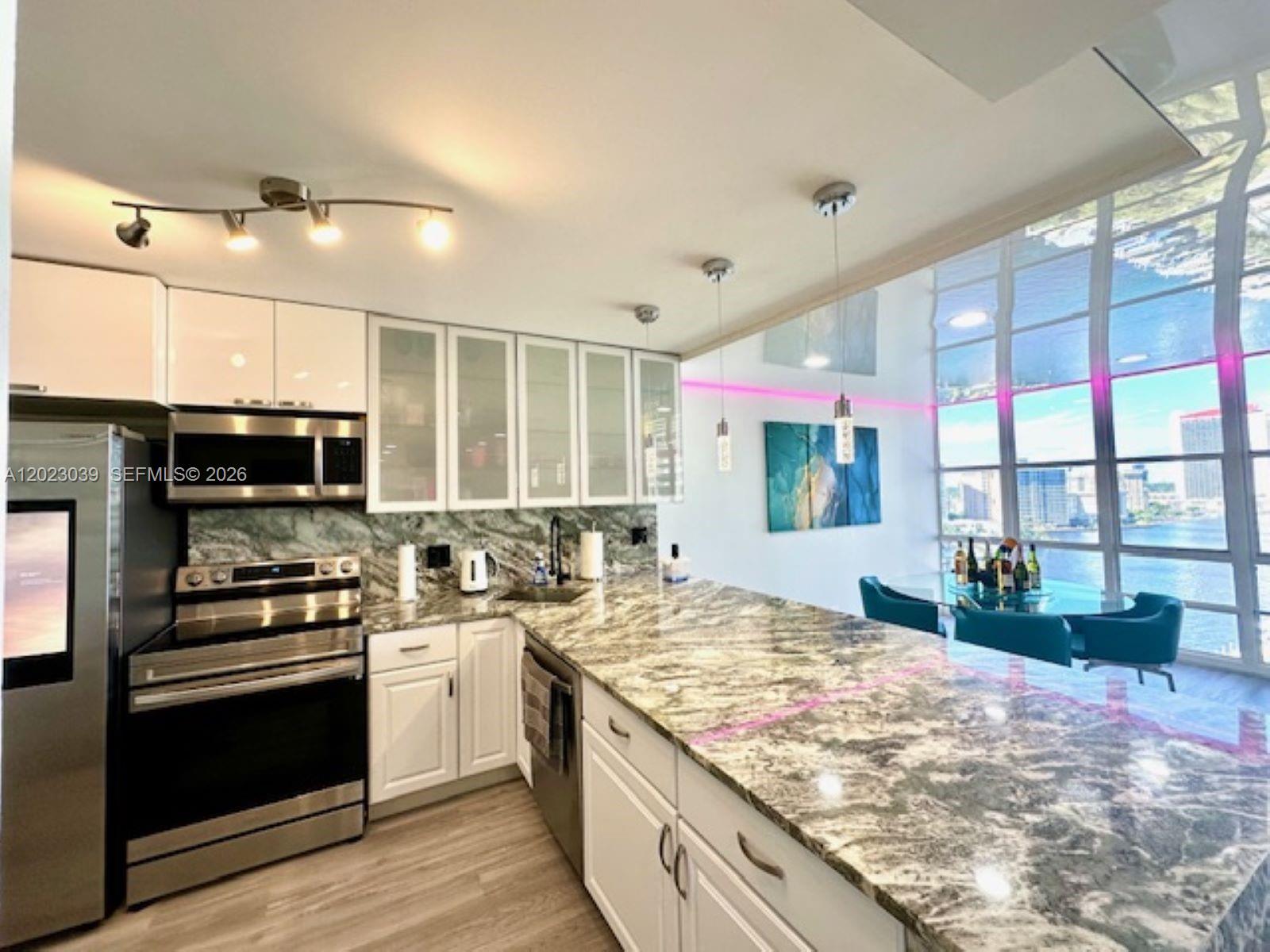 A kitchen with white cabinets, granite countertops, and a view of the city skyline — 2017 S Ocean Dr # 1107, Hallandale Beach FL 33009, HALLANDALE BEACH, FL