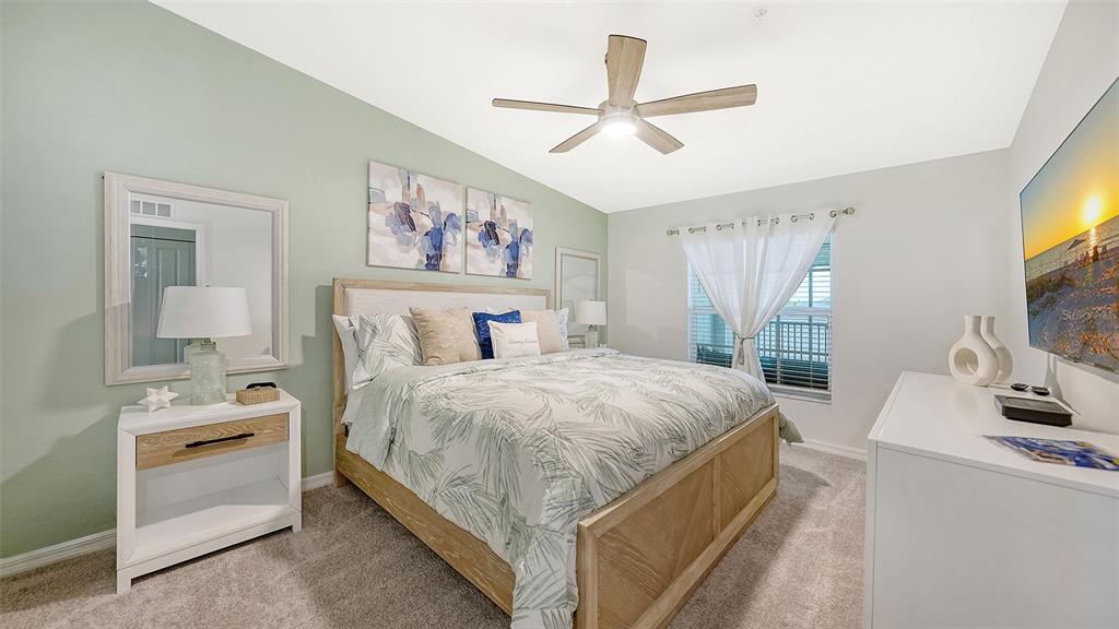 A bedroom features a light wood bed frame, a white dresser, and a ceiling fan — 12550 GALAPAGOS COURT UNIT 206, VENICE, FL