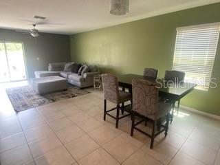 A living room and dining area with tile floors, a sectional sofa, and a table — 15510 WICKED STRONG STREET, SUN CITY CENTER, FL