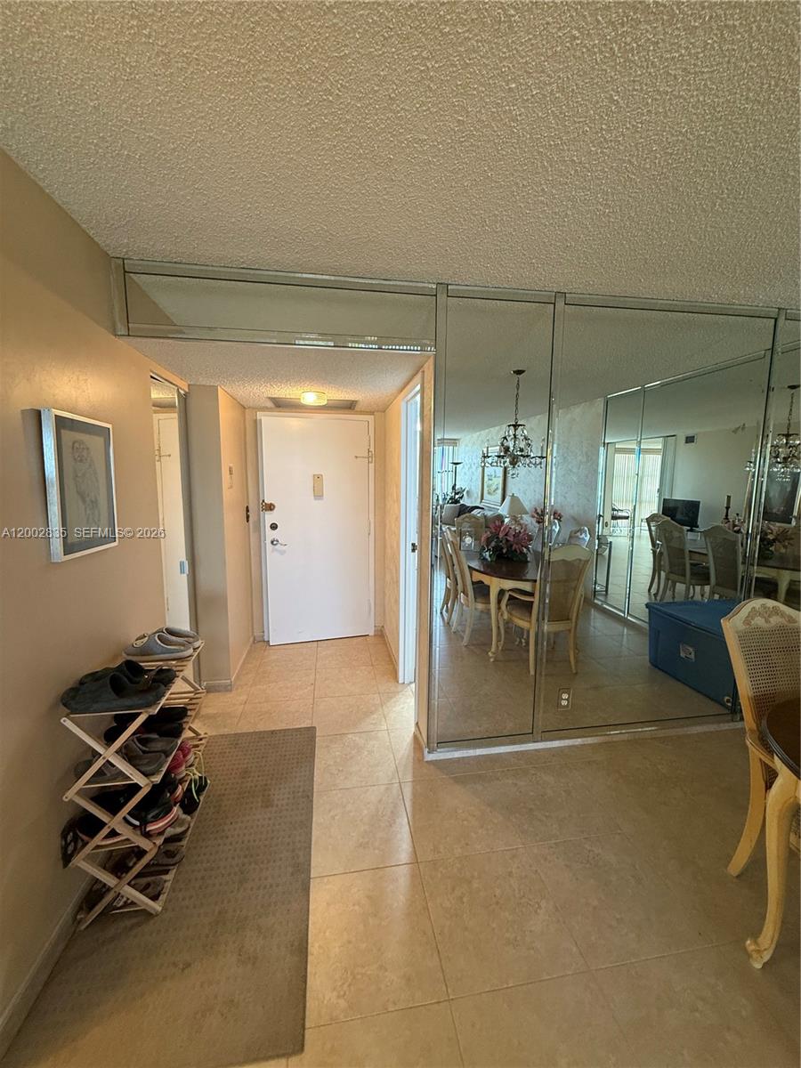An entryway features a tiled floor, a shoe rack, and a large mirrored wall — 1000 Parkview Dr # 407, Hallandale Beach FL 33009, HALLANDALE BEACH, FL
