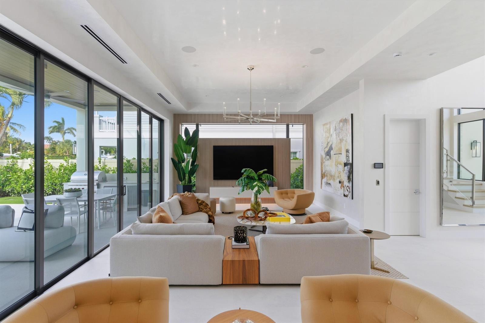 A modern living room features a large sectional sofa, a television wall, and floor-to-ceiling windows — 511 Silver Lane, Boca Raton FL 33432, BOCA RATON, FL