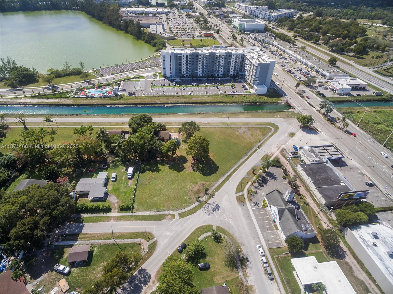 An aerial view shows a residential apartment building, a canal, and surrounding commercial and residential properties — 272 Street, Naranja FL 33032, NARANJA, FL