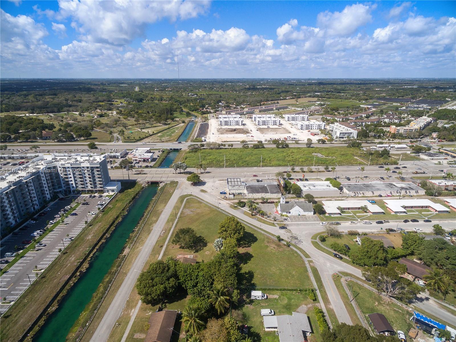 An aerial view shows a canal, a large apartment complex, and surrounding suburban development — 272 Street, Naranja FL 33032, NARANJA, FL