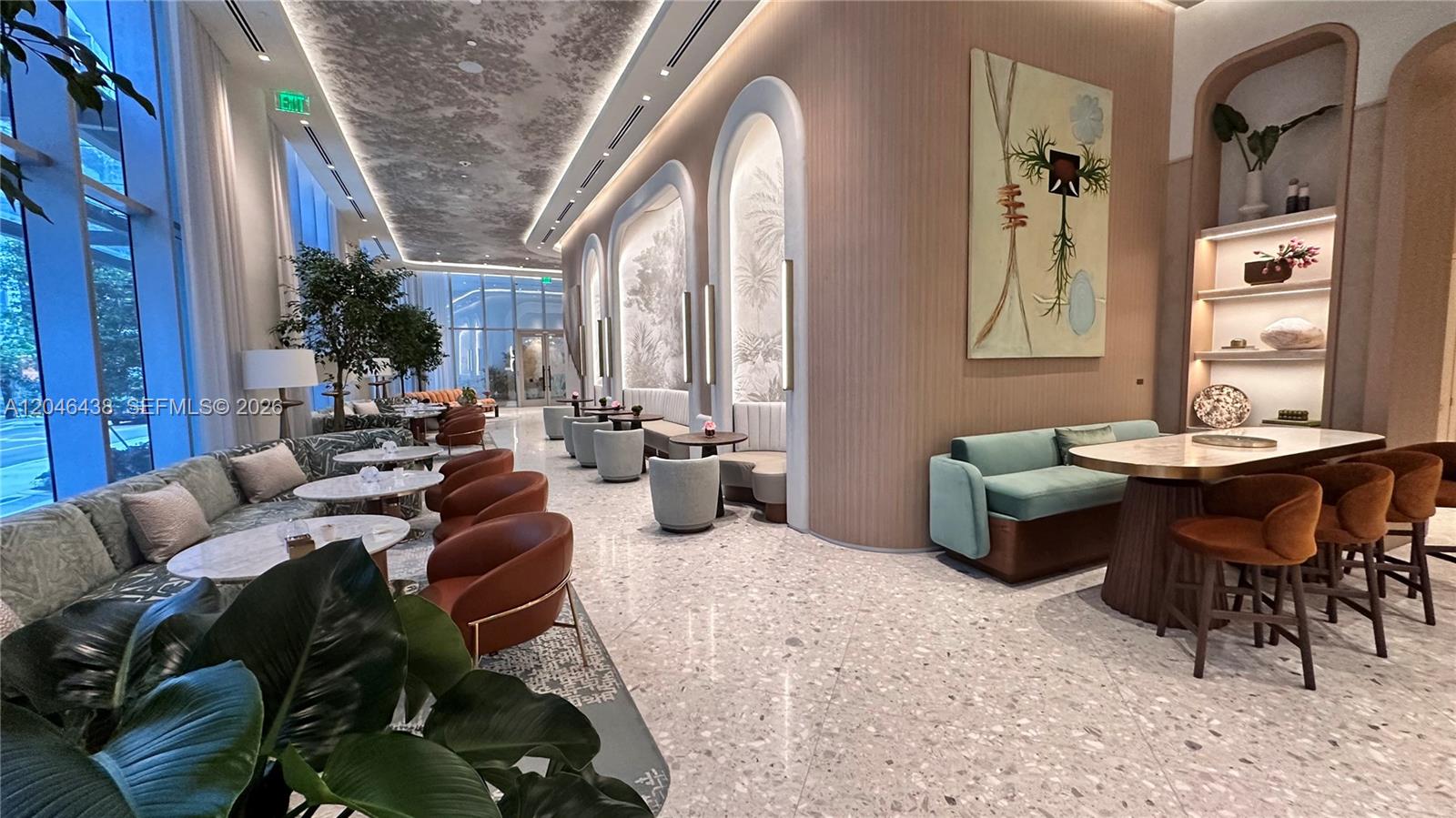 A modern lounge area features curved booths, brown armchairs, marble tables, and a textured ceiling — 77 SE 5th Street # 1915, Miami FL 33131, MIAMI, FL