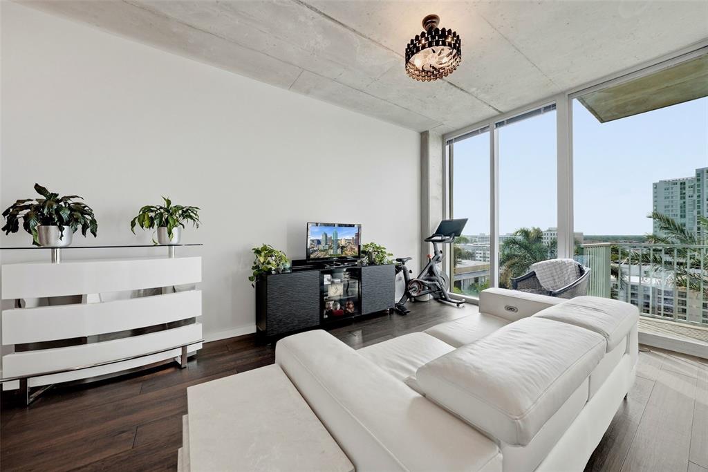 A living room features a white sofa, a black media console, and floor-to-ceiling windows — 777 N ASHLEY DRIVE UNIT 1109, TAMPA, FL