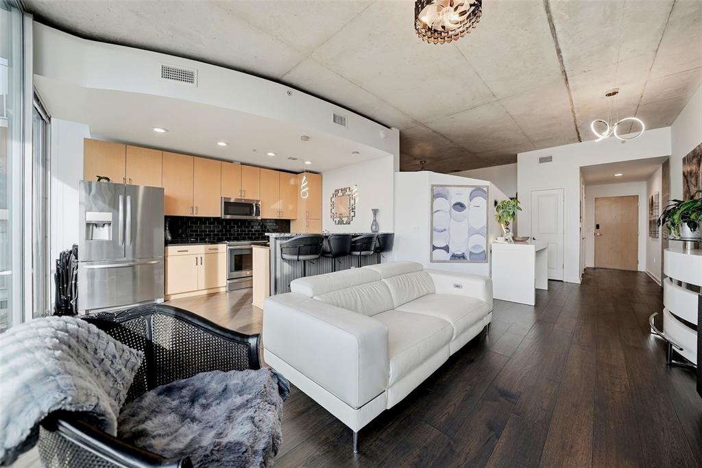 A modern open-concept living room and kitchen featuring light wood cabinets and concrete ceilings — 777 N ASHLEY DRIVE UNIT 1109, TAMPA, FL