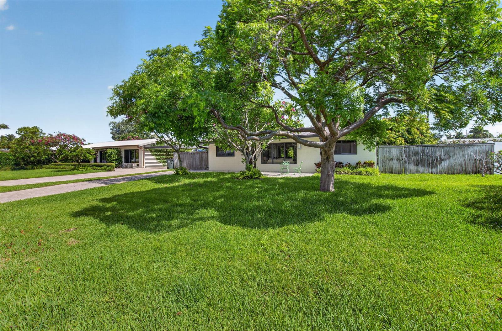 A single-story house with a large front lawn and mature trees under a blue sky — 115 NW 7th Street, Boca Raton FL 33432, BOCA RATON, FL