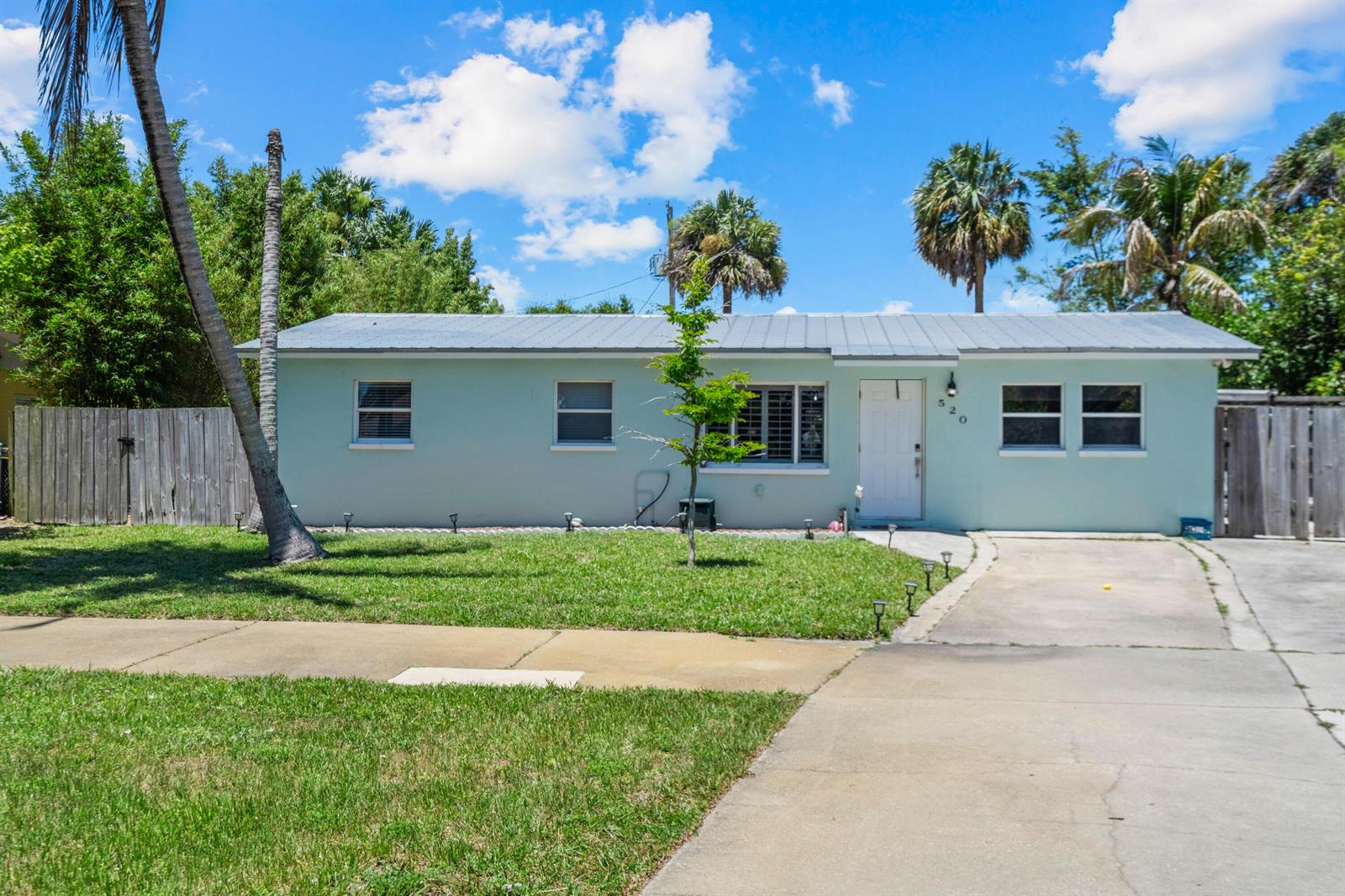 A light green, single-story house with a metal roof and a concrete driveway — 520 SE Dolphin Drive, Stuart FL 34996, STUART, FL
