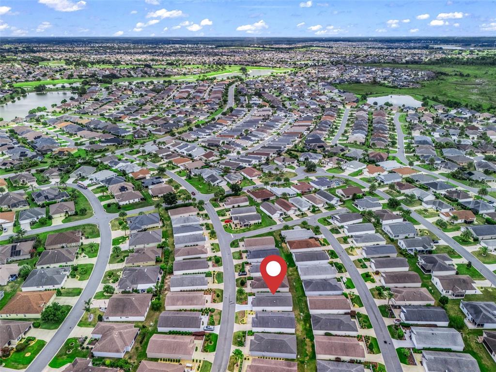 An aerial view shows a suburban neighborhood with a red location pin on a house — 1388 VIOLA COURT, THE VILLAGES, FL
