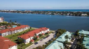 An aerial view shows multi-story apartment buildings with red roofs near a large body of water — 110 Half Moon Circle # E2, Hypoluxo FL 33462, HYPOLUXO, FL