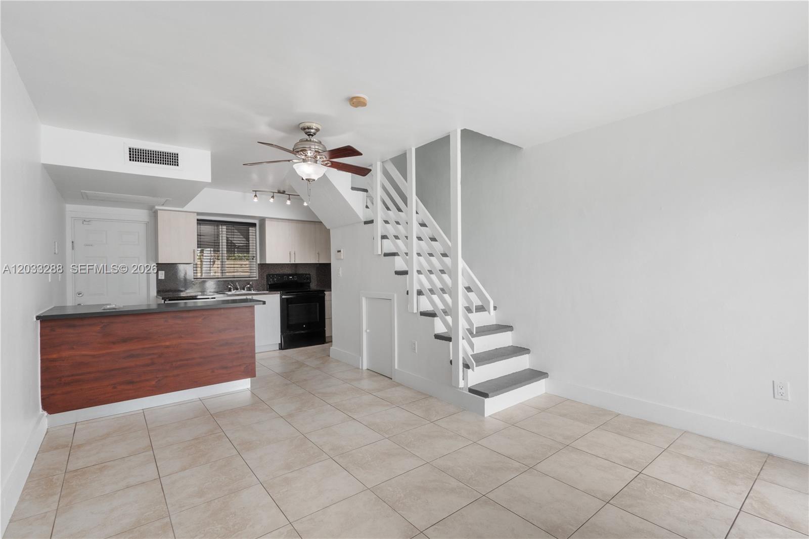 This room features a kitchen with a breakfast bar, tiled floors, and a staircase — 932 SW 6th St # 5, Miami FL 33130, MIAMI, FL