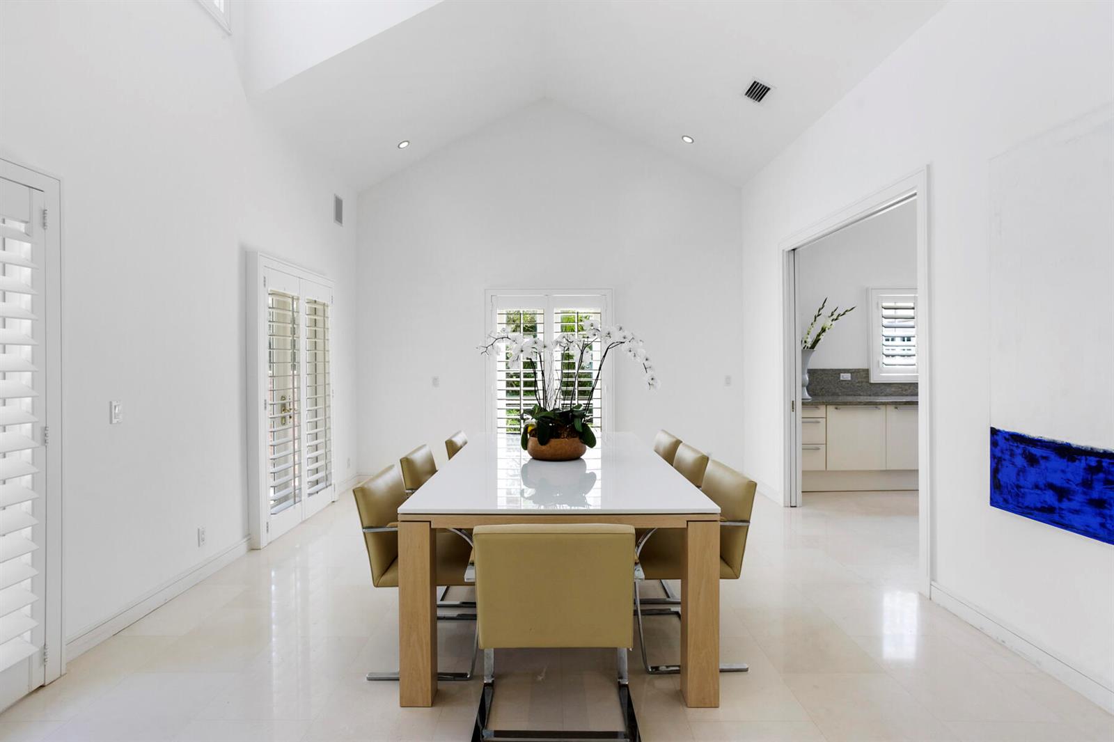 A bright dining room features a white table, tan chairs, and high vaulted ceilings — 222 Monterey Road, Palm Beach FL 33480, PALM BEACH, FL