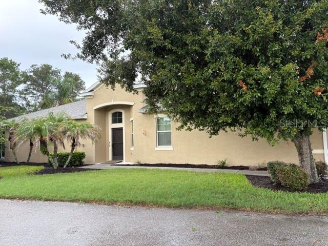 A tan stucco house features a screened-in porch with a white door and metal downspout — 2304 OAKLEY GREEN DRIVE UNIT 61, SUN CITY CENTER, FL