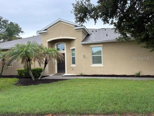 A screened-in patio with outdoor furniture is attached to the side of a tan house — 2304 OAKLEY GREEN DRIVE UNIT 61, SUN CITY CENTER, FL