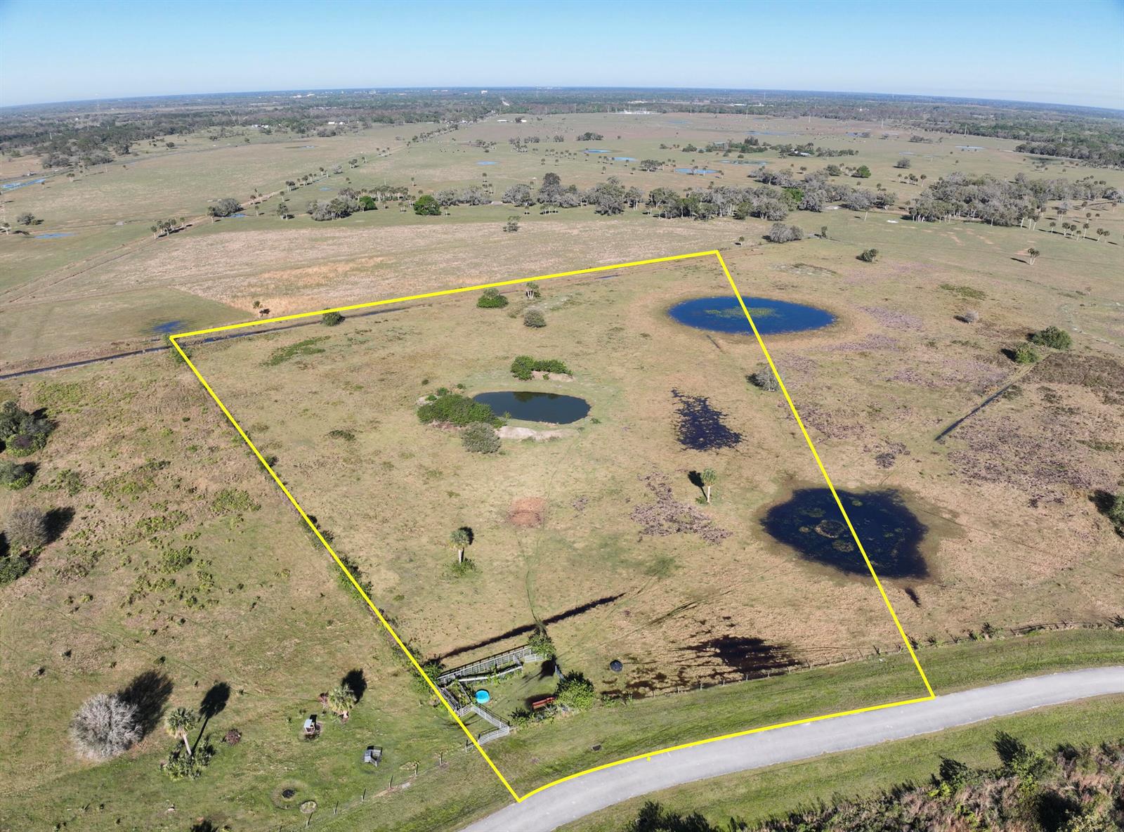 An aerial view shows a fenced, grassy lot with several ponds and a small structure — 6584 SE 26th Trail, Okeechobee FL 34974, OKEECHOBEE, FL