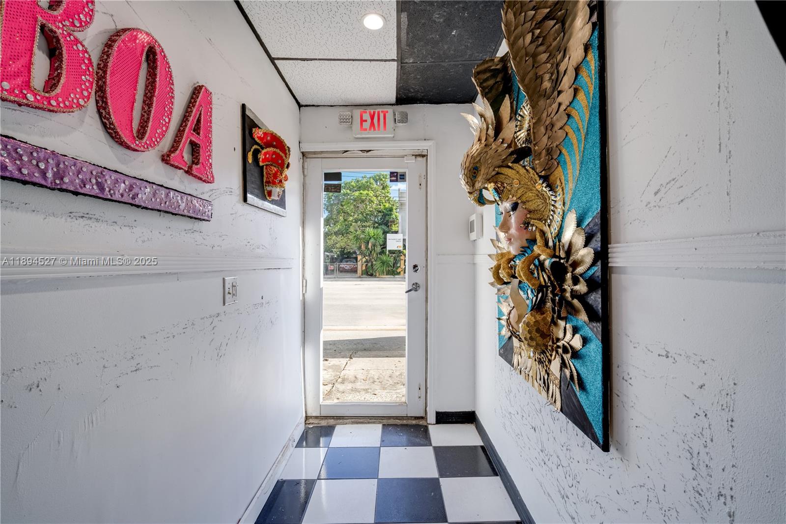 A narrow entryway features a checkered floor, a glass door, and decorative wall art — 2900 NW 11th Ave, Miami FL 33127, MIAMI, FL
