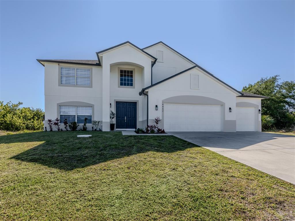 A two-story white house with a three-car garage and a dark blue front door — 14462 FORT WORTH CIRCLE, PORT CHARLOTTE, FL