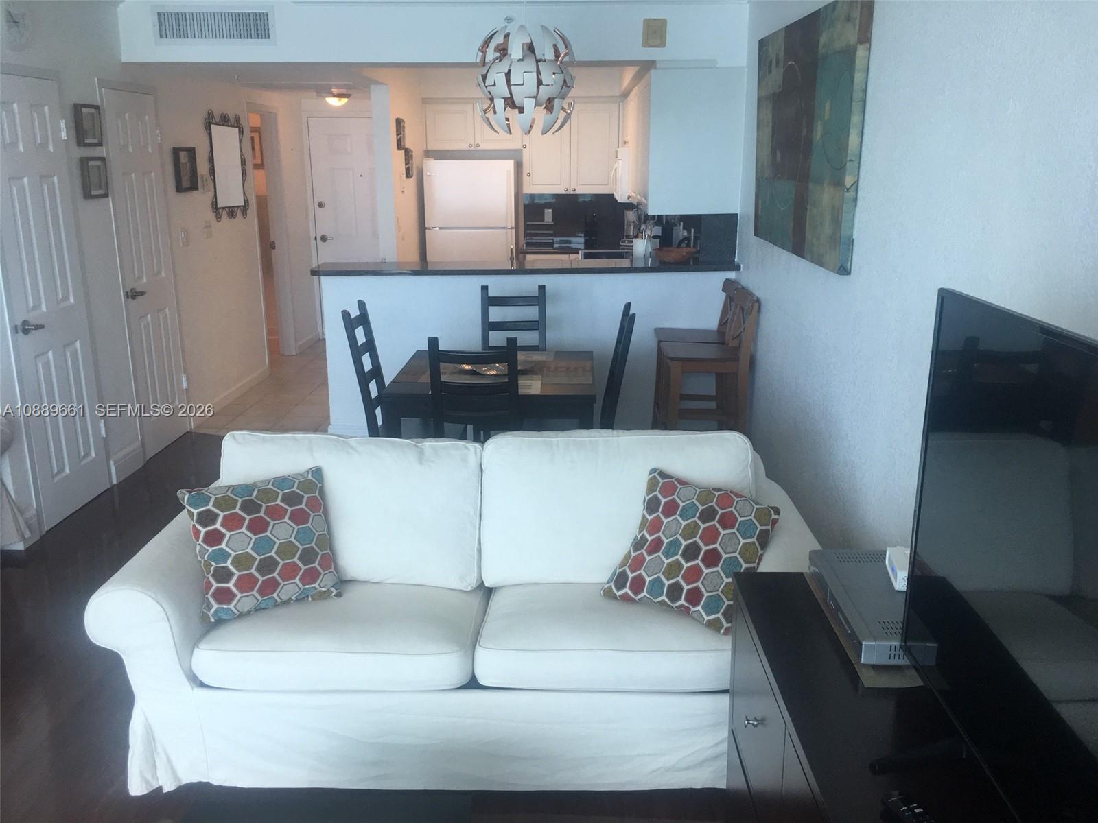 A white sofa sits in front of a dining area and an open kitchen — 2501 S OCEAN DR, Hollywood FL 33019, HOLLYWOOD, FL