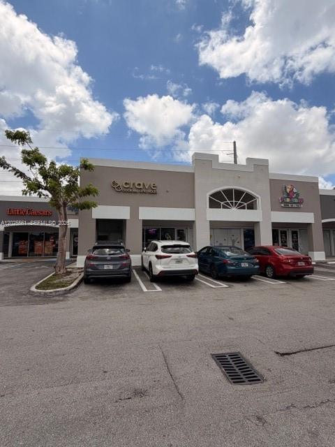 A strip mall exterior features a Little Caesars, a Crave shop, and a parked car — 10730 NW 58 STREET, Doral FL 33178, DORAL, FL