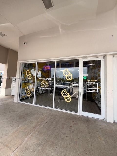 The exterior of a retail storefront features glass doors and windows with cookie-themed decals — 10730 NW 58 STREET, Doral FL 33178, DORAL, FL