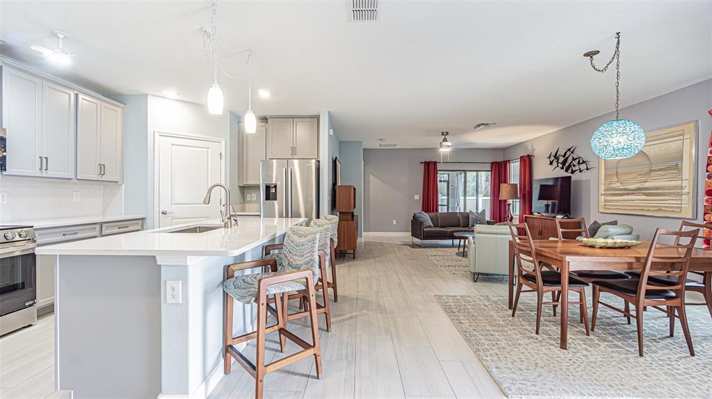 An open-concept kitchen with a large island flows into a dining and living area — 31310 CABANA RYE AVENUE, SAN ANTONIO, FL