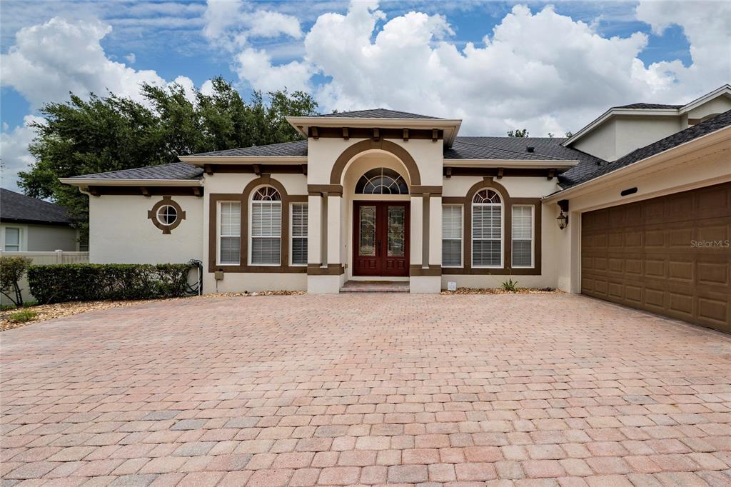 A single-story house with a paved driveway, arched entryway, and a two-car garage — 6230 BORDEAUX CIRCLE, SANFORD, FL