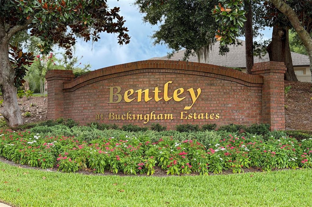A brick entrance sign for Bentley at Buckingham Estates sits behind a landscaped flower bed — 6230 BORDEAUX CIRCLE, SANFORD, FL