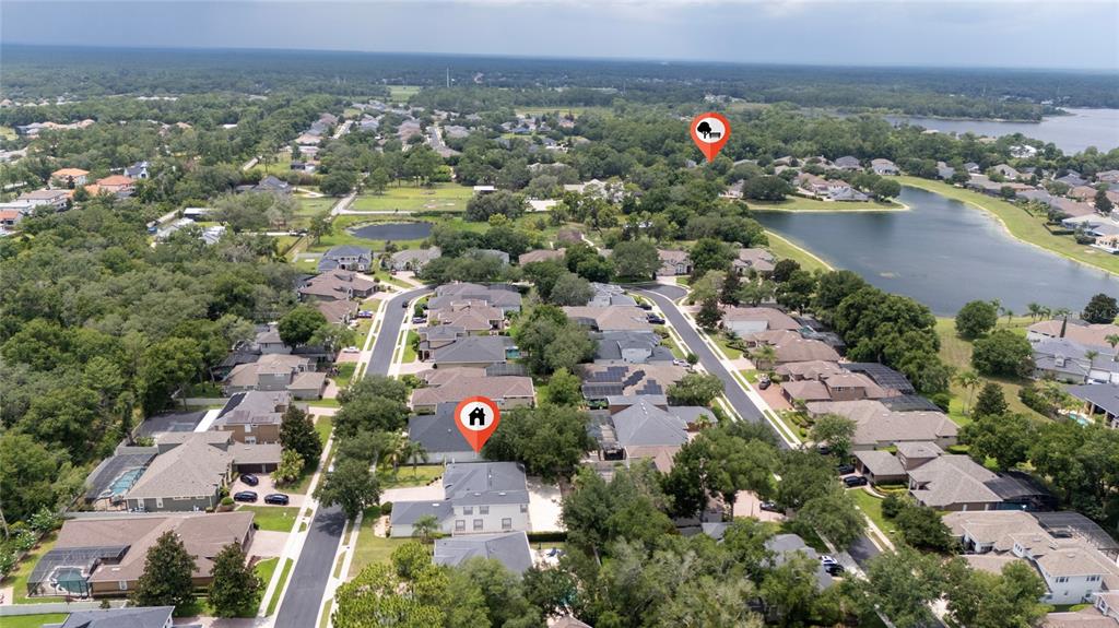 An aerial view shows a suburban neighborhood with houses, streets, and a nearby lake — 6230 BORDEAUX CIRCLE, SANFORD, FL